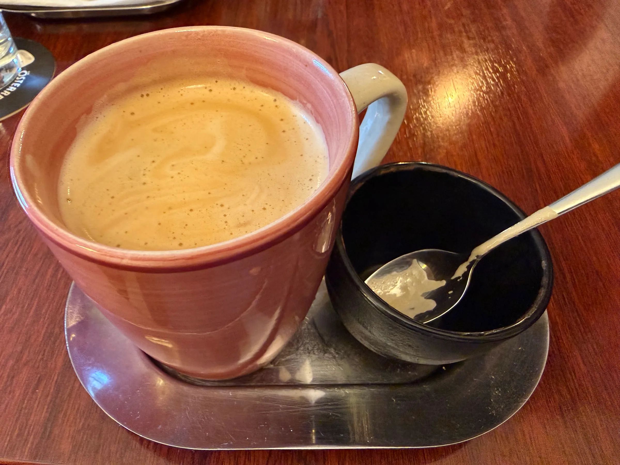 Melange in einer altrosa Tasse auf dem Holztisch